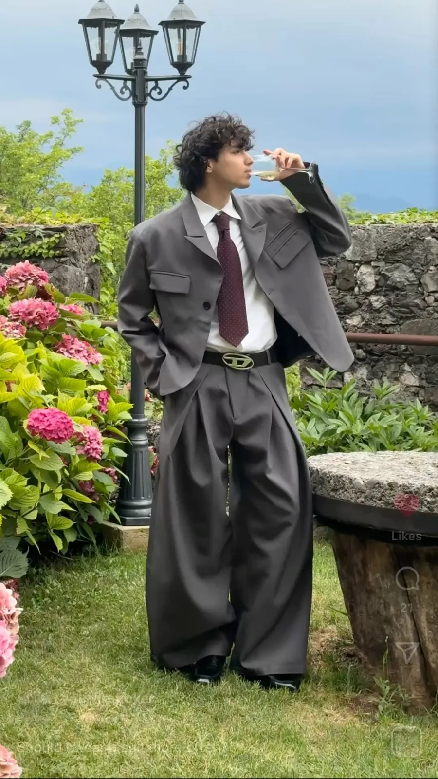 Androgynous aesthetic — The oversized, tailored suit with wide-leg trousers and a tie is a quintessential example of the Androgynous aesthetic, directly referencing the signature garments and silhouettes described.
