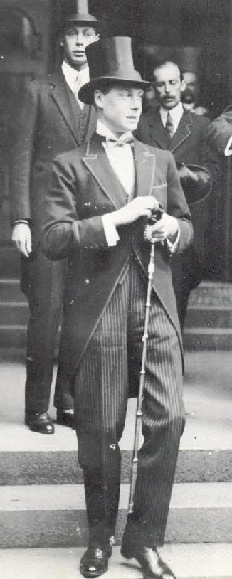 Dandy aesthetic — Black and white photograph of a man in a formal suit with a top hat and cane, embodying the classic dandy aesthetic and historical context.