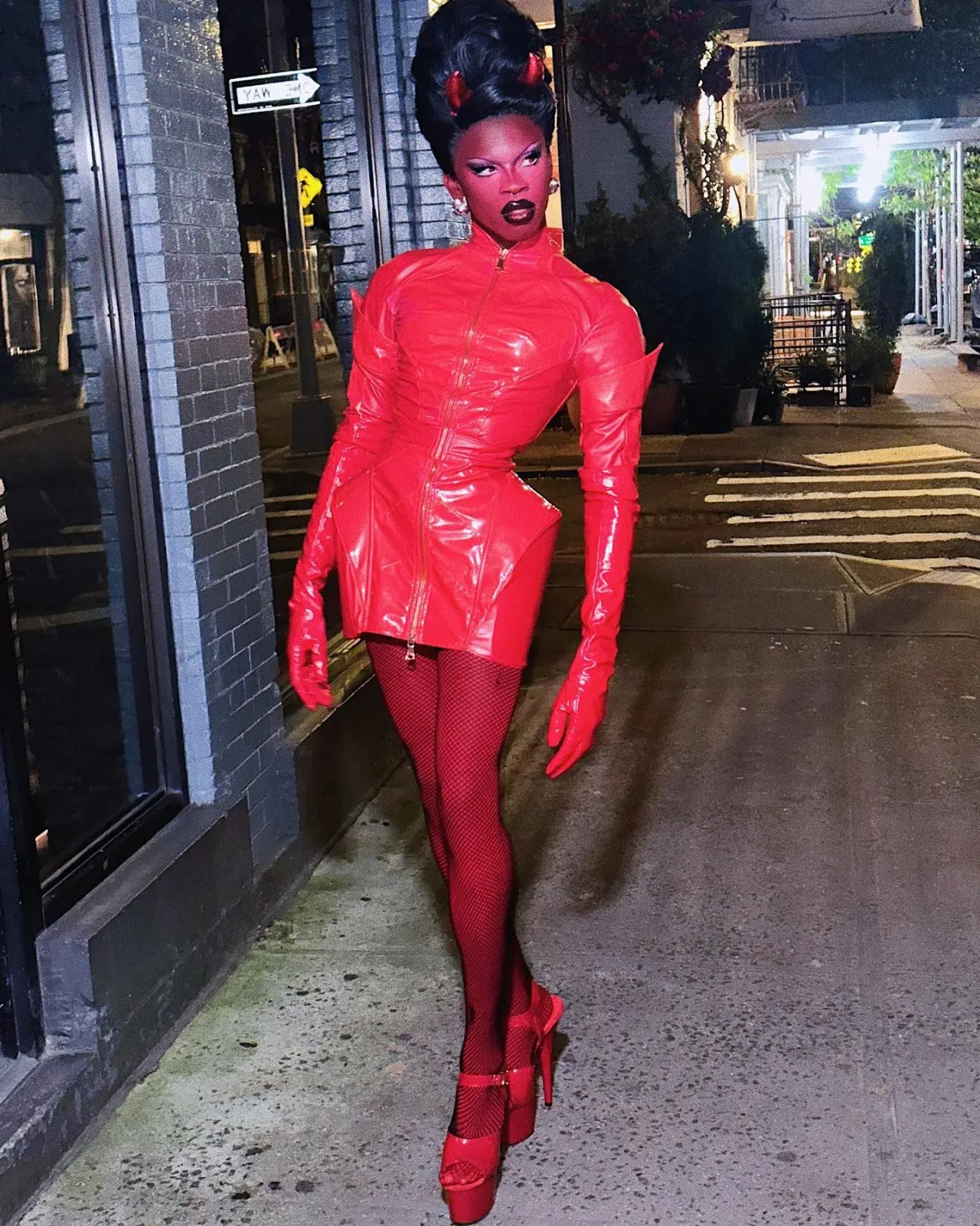 Devilcore aesthetic — This image perfectly embodies the 'wearable demon' with its red leather outfit, horns, fishnet, and theatrical makeup, directly referencing the description's visual signature and mood.