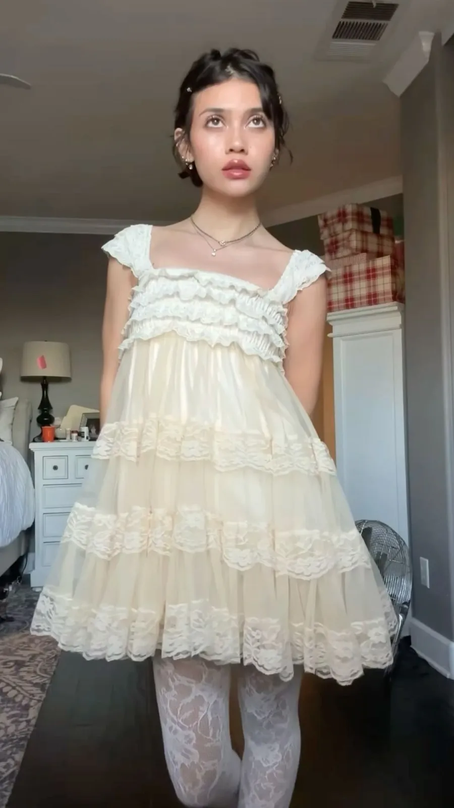Dollcore aesthetic — The image perfectly captures the Dollcore aesthetic with its porcelain-pale makeup, ringlets in the hair, a babydoll dress with ruffles and lace, and lace stockings. The overall presentation strongly evokes the desired doll-like fantasy.