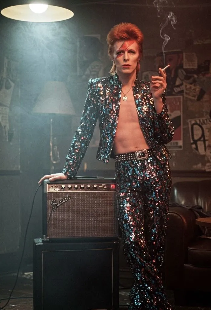 Glam Rock aesthetic — Iconic Ziggy Stardust look with sequined jumpsuit, face paint, and theatricality.