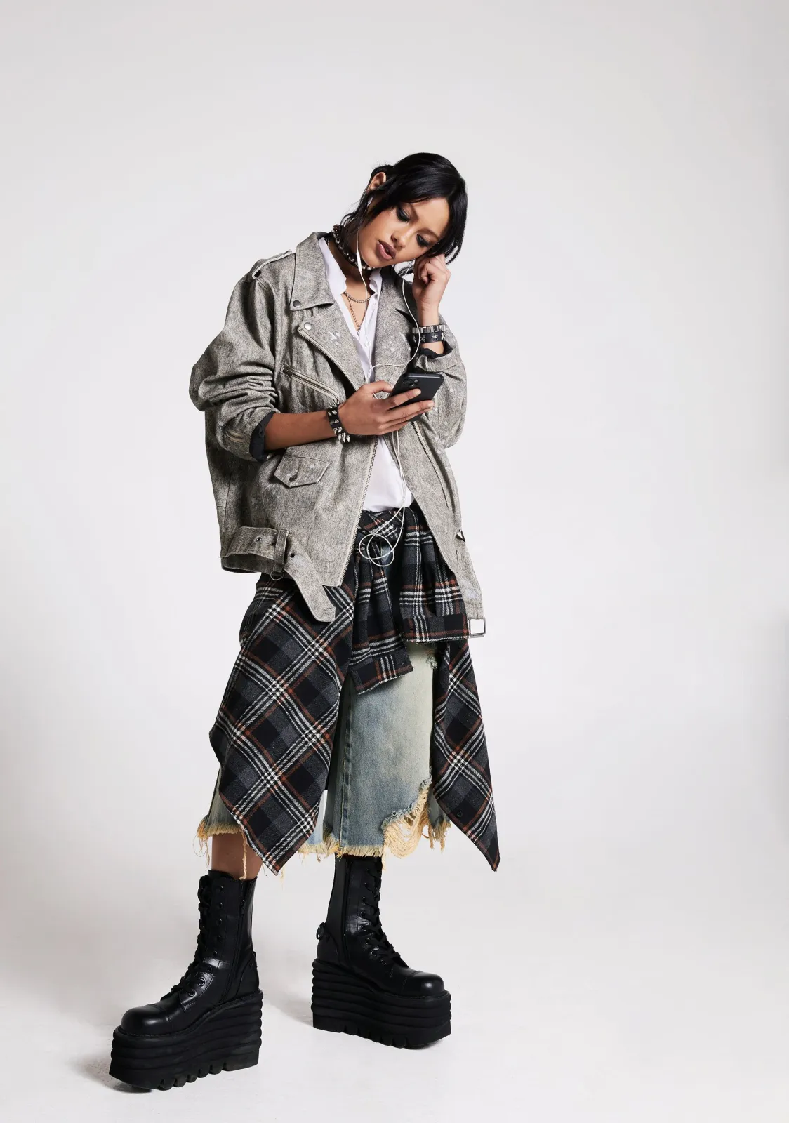 Grunge aesthetic — This image perfectly captures the grunge aesthetic with ripped denim, layered plaid, combat boots, and an oversized, worn-in silhouette.