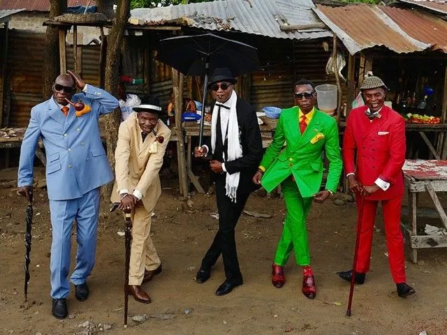La Sape aesthetic — This image perfectly encapsulates La Sape with its array of brightly colored, impeccably tailored three-piece suits, fedoras, canes, and co-ordinated accessories.