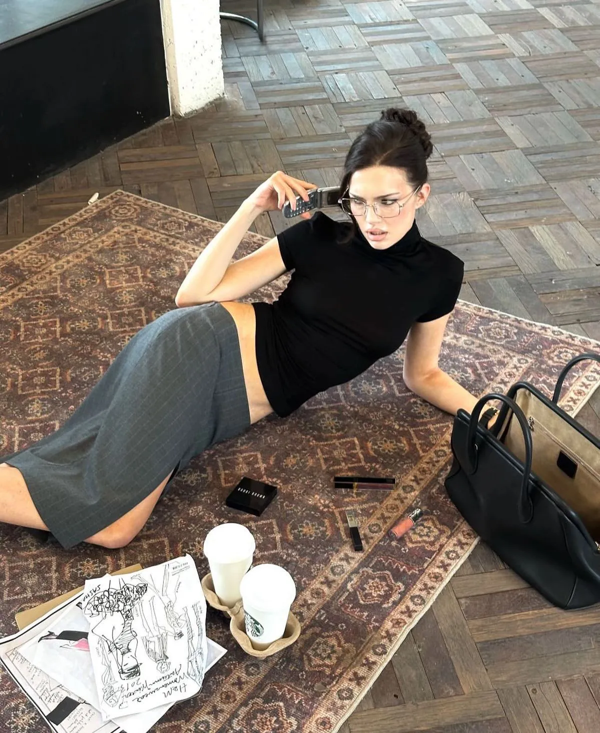 Office Siren aesthetic — The fitted turtleneck, pencil skirt, and narrow glasses, combined with the relaxed yet sensual pose and makeup, perfectly embody the Office Siren aesthetic.