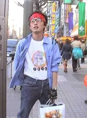 Otaku aesthetic — The red bandana, glasses, graphic tee with anime-style art, denim shirt, and casual jeans perfectly capture the described Otaku visual signature and functional, low-key style.