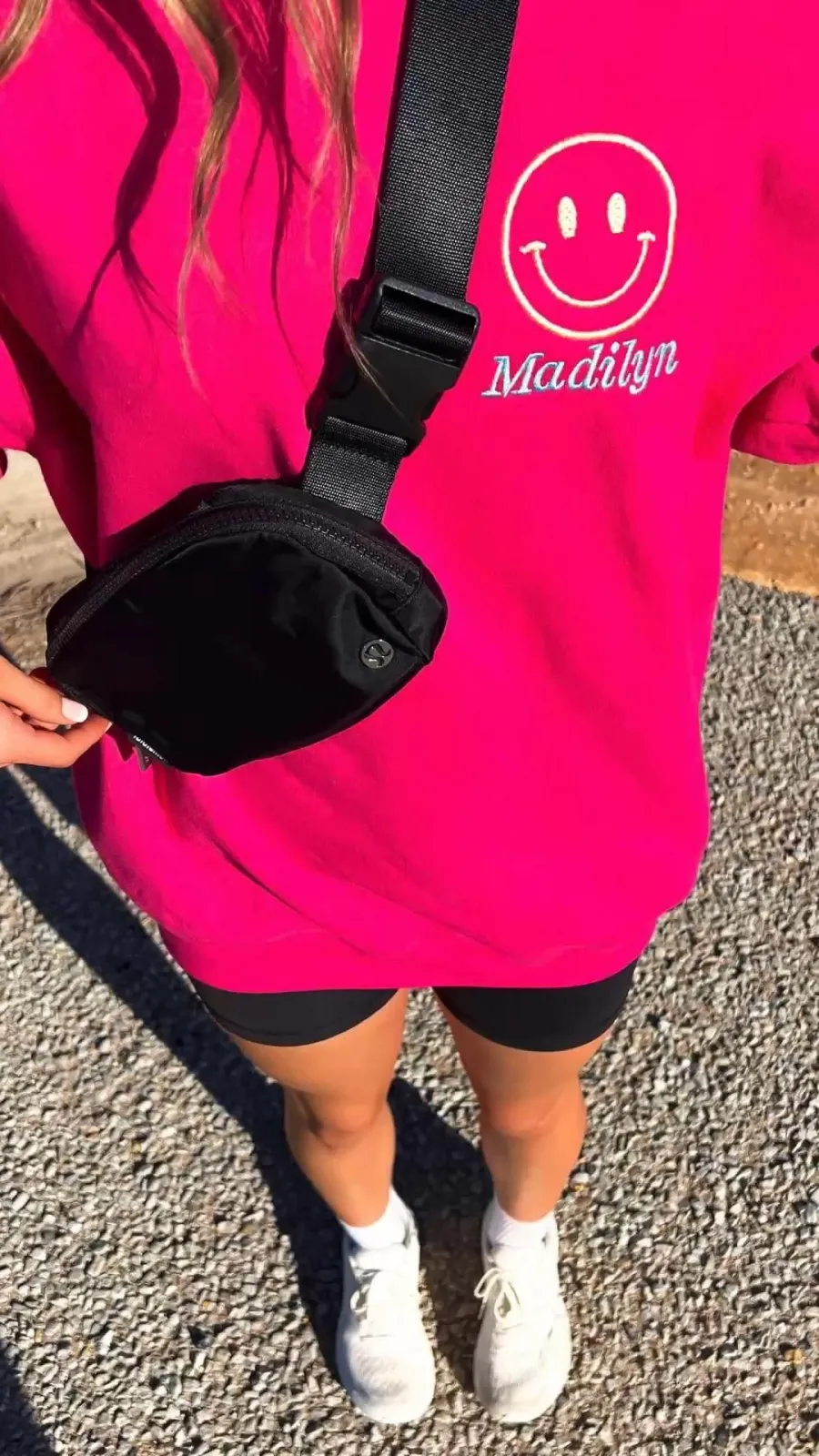 TikTok Preppy aesthetic — The hot pink smiley graphic tee and the black Lululemon belt bag are perfect representations.