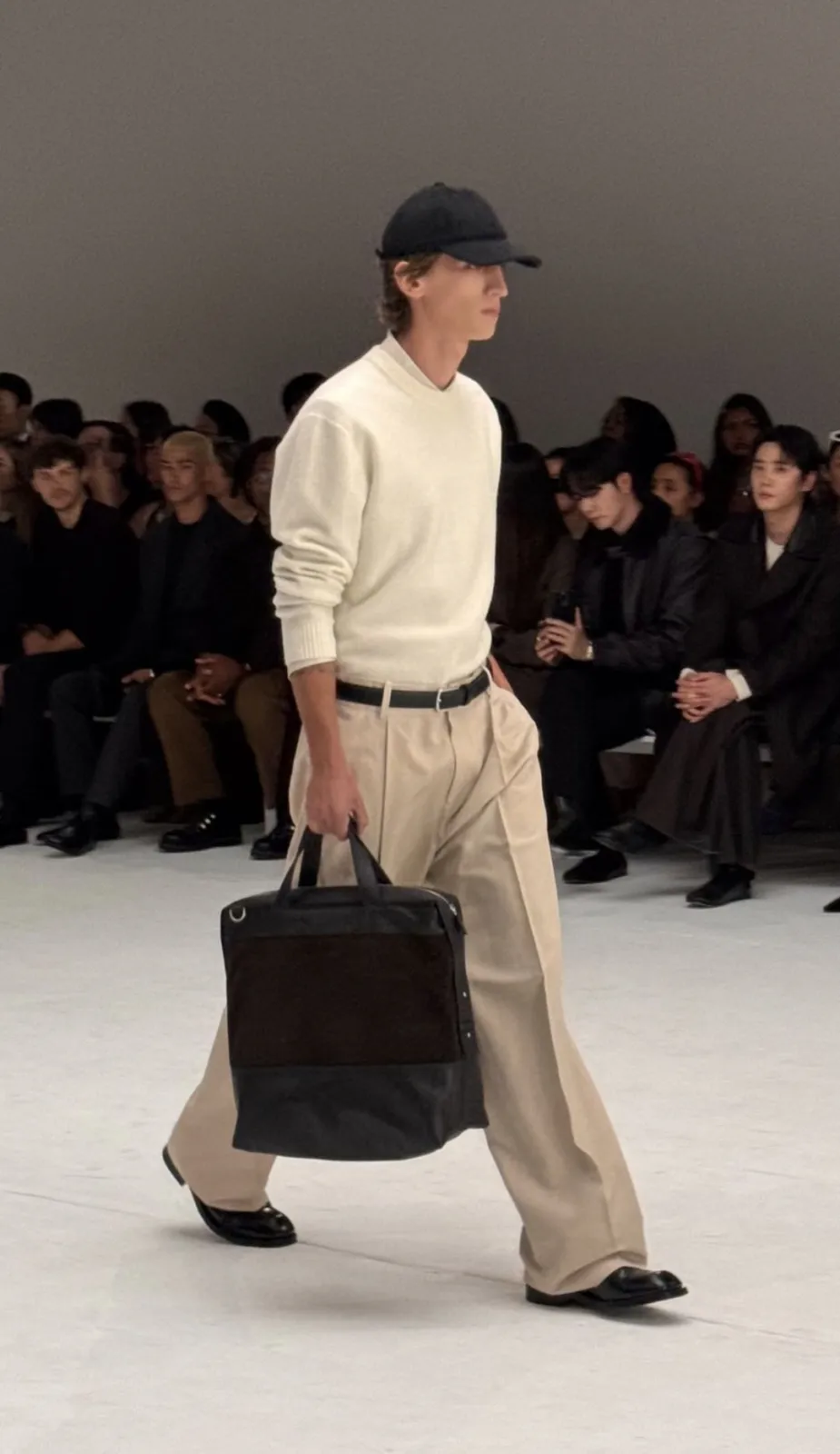 Quiet Luxury aesthetic — The cream fine-gauge knit, neutral tailored trousers, leather belt, and structured bag perfectly embody the quiet luxury aesthetic's emphasis on expensive materials and subtle branding.