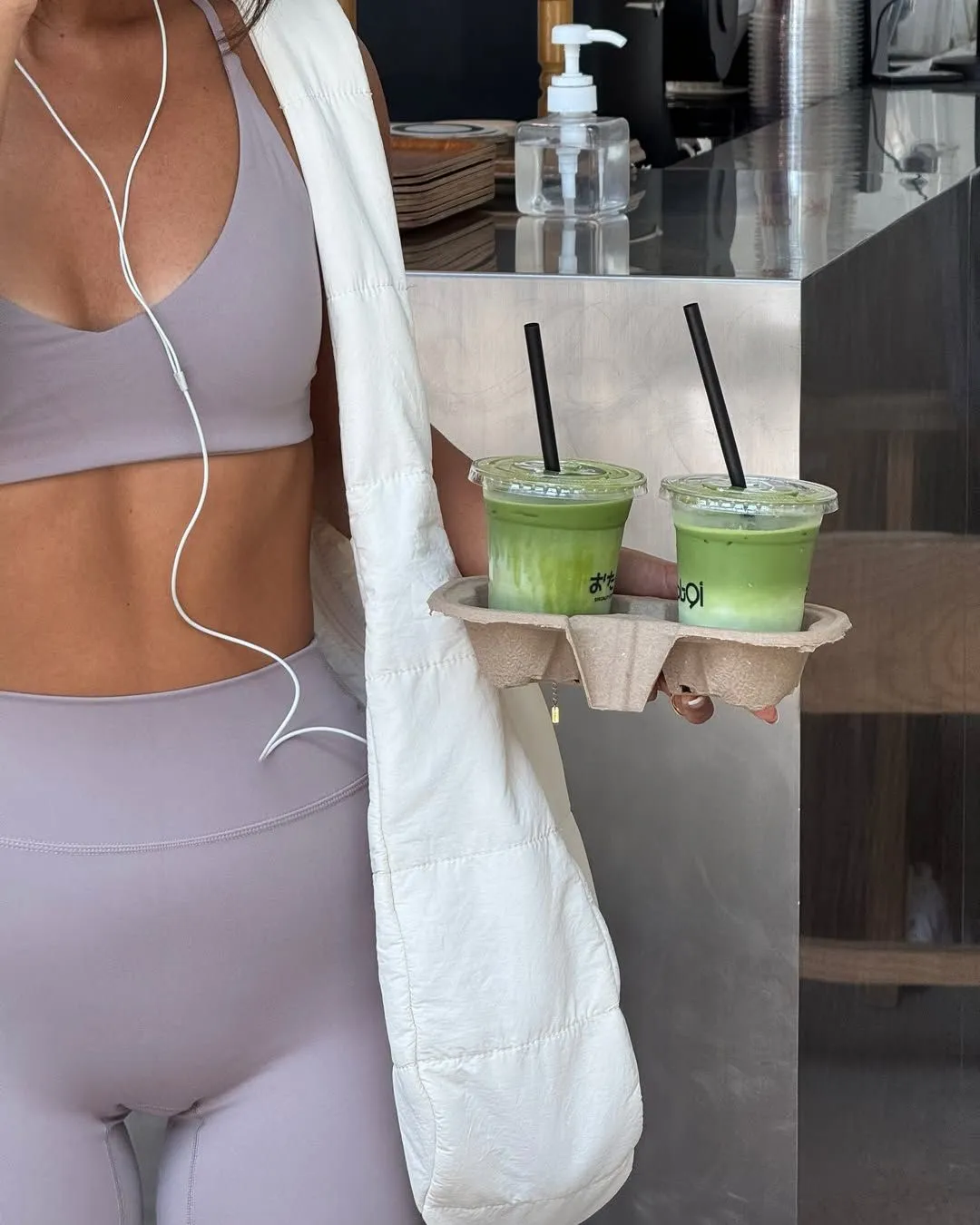 That Girl aesthetic — The image perfectly captures the "That Girl" aesthetic with the matching athleisure set (likely Lululemon Align leggings and a sports bra in a neutral tone), the iced matcha lattes, and the overall vibe of a curated wellness routine.