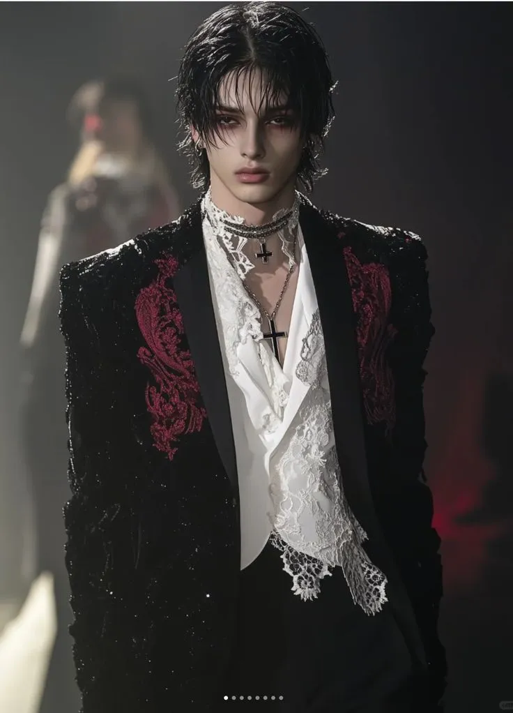 Vampire aesthetic — The model's pale skin, kohl-rimmed eyes, blood-red lips, and the ornate, aristocratic tailoring of the jacket with lace details are a direct embodiment of the description's visual signature and makeup.
