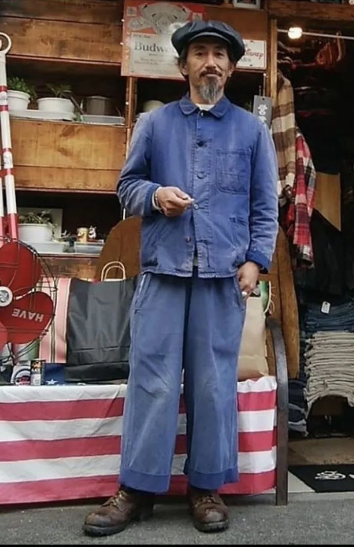 Workwear aesthetic — This image perfectly captures the heritage aspect with the chambray work shirt, loose-fitting work pants, and worn-in look, strongly aligning with canonical brands and visual cues.