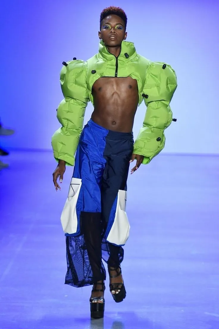Y2K Futurism aesthetic — The neon green puffer jacket with exaggerated sleeves, combined with the blue and white color blocking and platform shoes, strongly embodies the 'neon-and-silver palette,' 'blobjects,' and 'futuristic boots' visual signature.